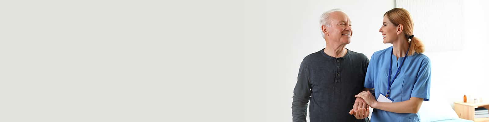 a caregiver with an elderly man walking