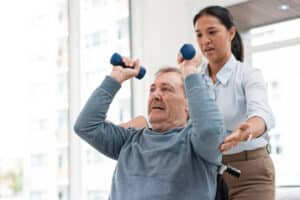 Lakeside Post Acute rehabilitation specialist helping resident lift small weights